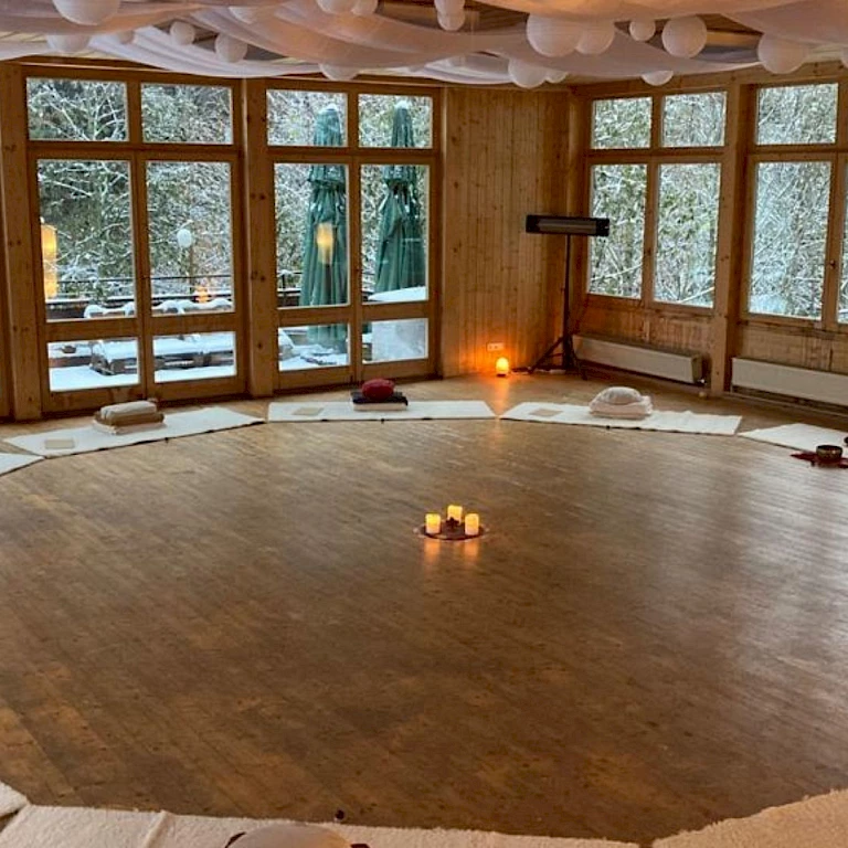 Seminarraum bereit für die Auszeit in Bergstille – Meditationskissen im Kreis, Kerzenlicht und Ruhe für den Start ins Achtsamkeitsseminar