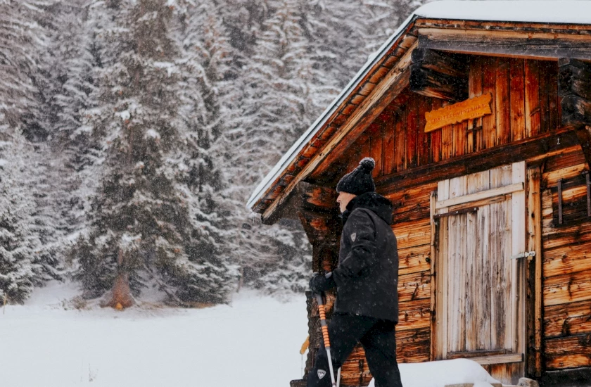 Auf Schneeschuhen geht es an Hütten und Alpen vorbei durchs Tal